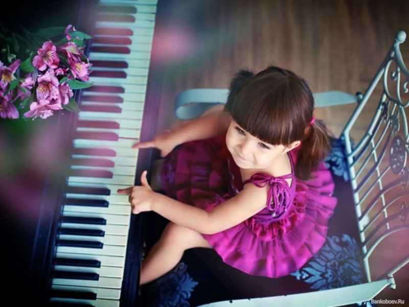 Девочка играет на пианино и поет
